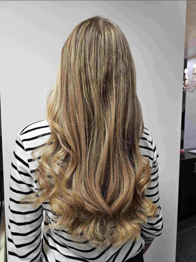 Lange blonde Haare mit Locken und Strähnen – Kundenarbeit Coiffeur Thun